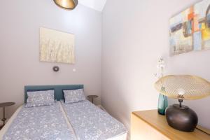 Un dormitorio con una cama y una lámpara en un tocador en New York Cafe Apartment in Center, en Budapest