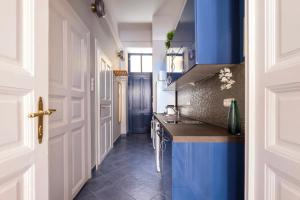 una cocina con armarios azules y fregadero en New York Cafe Apartment in Center, en Budapest