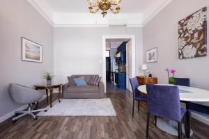 a living room with a couch and a table and chairs at New York Cafe Apartment in Center in Budapest