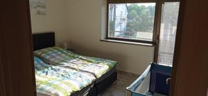 a small bedroom with a bed and a window at LAVENDER APARTMENT in Balatonboglár
