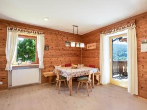 - une salle à manger avec une table et deux fenêtres dans l'établissement Huanzhof Ferienwohnung Schwarzhorn, à Aldino