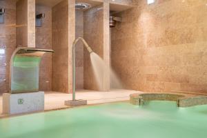 a large pool of water in a room with a shower at 3HB Faro in Faro