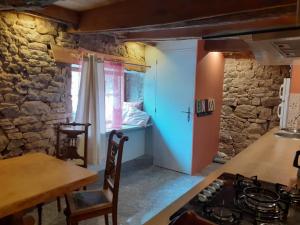a kitchen with a stove and a table and a bedroom at Gite Ramana in Montcléra