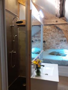 ein Bad mit einem Waschbecken und ein Bett in einem Zimmer in der Unterkunft Gite Ramana in Montcléra