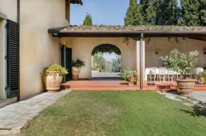 patio z krzesłami i łukiem w obiekcie Villa Faltoiano w mieście Lastra a Signa