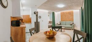 a kitchen and a table with a bowl of fruit on it at Hej na Mazury Apartamenty in Ruciane-Nida +21 photos