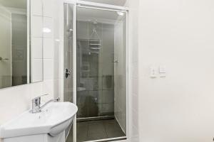 a bathroom with a sink and a shower at Surf Beach Motel Coffs in Coffs Harbour