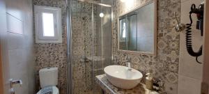 a bathroom with a sink and a toilet and a mirror at Pension Alexandra in Parga +57 photos