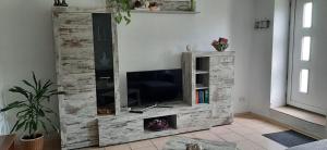 a wooden entertainment center with a television in a living room at Feriendomizil-Roger-Wohnung-1 in Leipzig