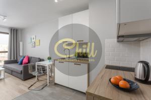 a kitchen and a living room with a table at Chill Apartments City Link in Warsaw