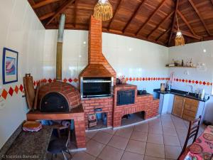 a kitchen with a fire place and a fireplace at Pousada Eldorado Das Gerais in Carrancas