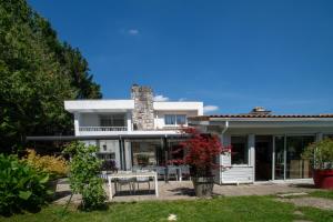 a white house with a table and chairs in a yard at Maison Lucilda in Pessac