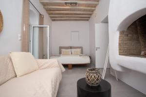 a living room with a bed and a couch at Flaskos Village Fanari in Mýkonos City