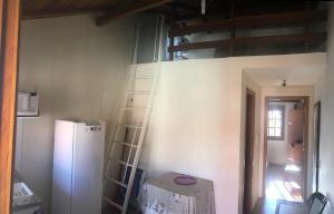 een keuken met een witte koelkast en een ladder bij POUSADA TAQUARAS in Cassino