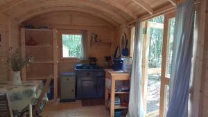 uma pequena cozinha com um fogão e uma janela em Lovely 2-Bed shepherds hut in a Forest em Sougères-en-Puisaye