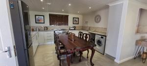a kitchen with a table and a sink and a dishwasher at DullVino House Dullstroom in Dullstroom