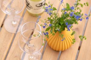 una mesa con dos copas de vino y un jarrón con flores azules en BLEIBE4 Ferienwohnungen en Wunsiedel