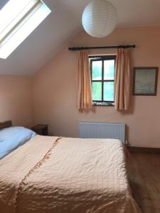 a bedroom with a bed and a window at Teach an Ghleanna in Glengarriff