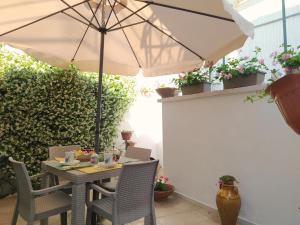 a table and chairs with an umbrella on a patio at Il trullo di nonna Antonia in Alberobello