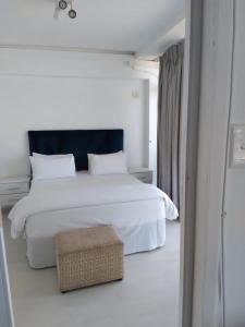 a white bedroom with a white bed and a window at 86 windermere self catering apartments in Durban