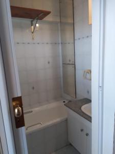 Baño blanco con bañera y lavamanos en 86 windermere self catering apartments, en Durban