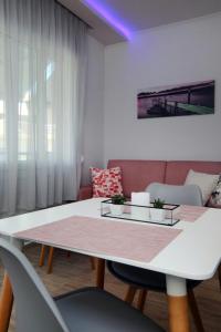 a living room with a white table and chairs at SunsetPeramos in Néa Péramos