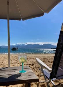 una copa de vino sentada en una mesa en la playa en O Sitio - Ilha Grande en Abraão