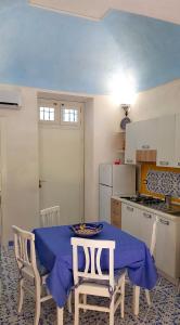 een keuken met een tafel met een blauwe tafeldoek erop bij Il Limoneto di Lulù, holidays among the lemon trees in Minori