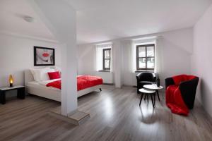 biała sypialnia z łóżkiem i krzesłem w obiekcie Apartamenty KAPRYS w mieście Duszniki Zdrój
