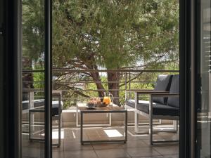 a balcony with a table and chairs and a tree at La Palma Apartment in Zakynthos Town