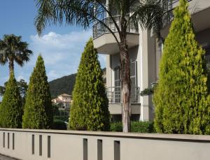 a row of trees in front of a building at La Palma Apartment in Zakynthos Town