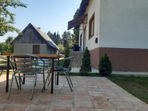 uma mesa e cadeiras sentadas ao lado de uma casa em Country house Plitvice em Plitvica selo