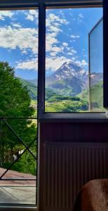 a view of a mountain from a window at Kazbegi Inn in Stepantsminda