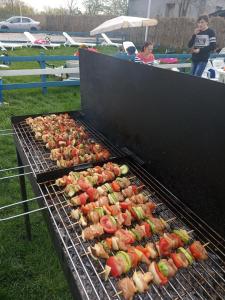 a grill with chickens and vegetables cooking on it at Camping Danubius Tulcea in Tulcea +45 photos