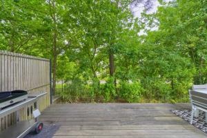 a deck with a grill and a bench and trees at La Carasse in Lège-Cap-Ferret
