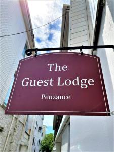 a sign that reads the guest lodge pennsylvania hanging from a building at Guest Lodge Penzance in Penzance