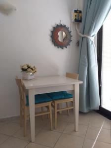 una mesa con 2 sillas y una cortina azul en Sea Side Studio, en Viareggio