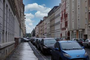a city street with parked cars and buildings at Gut und Günstig in Leipzig - zentrumsnah - inkl Fahrräder, Netflix und Tiefgaragenstellplatz in Leipzig +21 photos