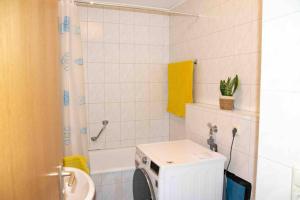 a bathroom with a washing machine and a sink at Gut und Günstig in Leipzig - zentrumsnah - inkl Fahrräder, Netflix und Tiefgaragenstellplatz in Leipzig