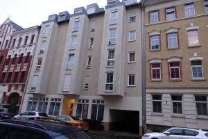 a group of buildings with cars parked in front of them at Gut und Günstig in Leipzig - zentrumsnah - inkl Fahrräder, Netflix und Tiefgaragenstellplatz in Leipzig