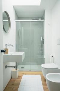 Baño blanco con ducha de cristal y lavabo en La Caliera di Mati, en Roncade