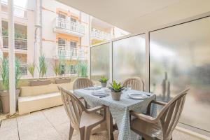 a dining room with a table and chairs on a balcony at La Pause Bassin, charmant appartement dans le centre in Arcachon