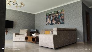 a living room with a couch and two chairs at Green Apartment in Kazbegi