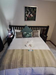 Harties Honeymoon Suite with Dam View في هارتبيسبورت: سرير كبير عليه منشفتين بيضاء