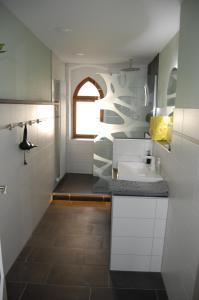 a white bathroom with a sink and a window at Hochwertige Ferienwohnung/zentrumsnahe Lage! in Reichenbach im Vogtland