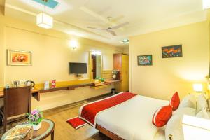 a hotel room with a bed and a tv at Octave Kanthi Comforts in Bangalore