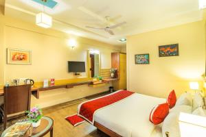 Una habitación de hotel con una cama y un televisor. en Octave Kanthi Comforts, en Bangalore