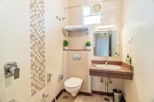 a bathroom with a toilet and a sink at Octave Kanthi Comforts in Bangalore