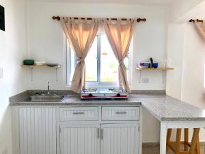 a kitchen with a sink and a window at Bungalow 19 Cozy room at just steps from the beach and in town center in Sosúa