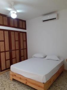 een bed in een kamer met een wit matras bij Bungalow 21 Cozy room at just steps from the beach and in town center in Sosúa